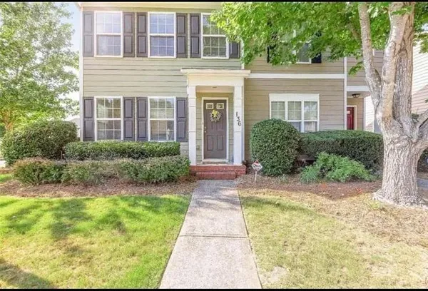 front view of a brick house with a yard