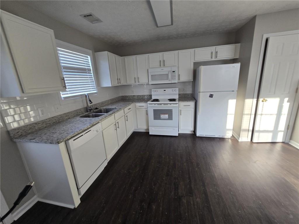 136 Alice Walker Drive Athens, GA 30607 - Photo 3 of 11 a kitchen with stainless steel appliances a sink dishwasher a refrigerator a stove and white cabinets with wooden floor