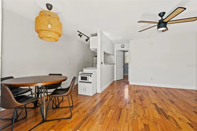 a view of a room with wooden floor table and a chandelier