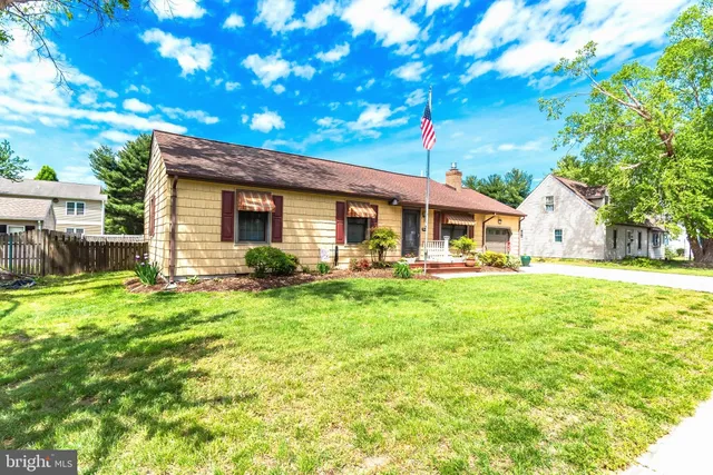 a view of a house with backyard and a tree