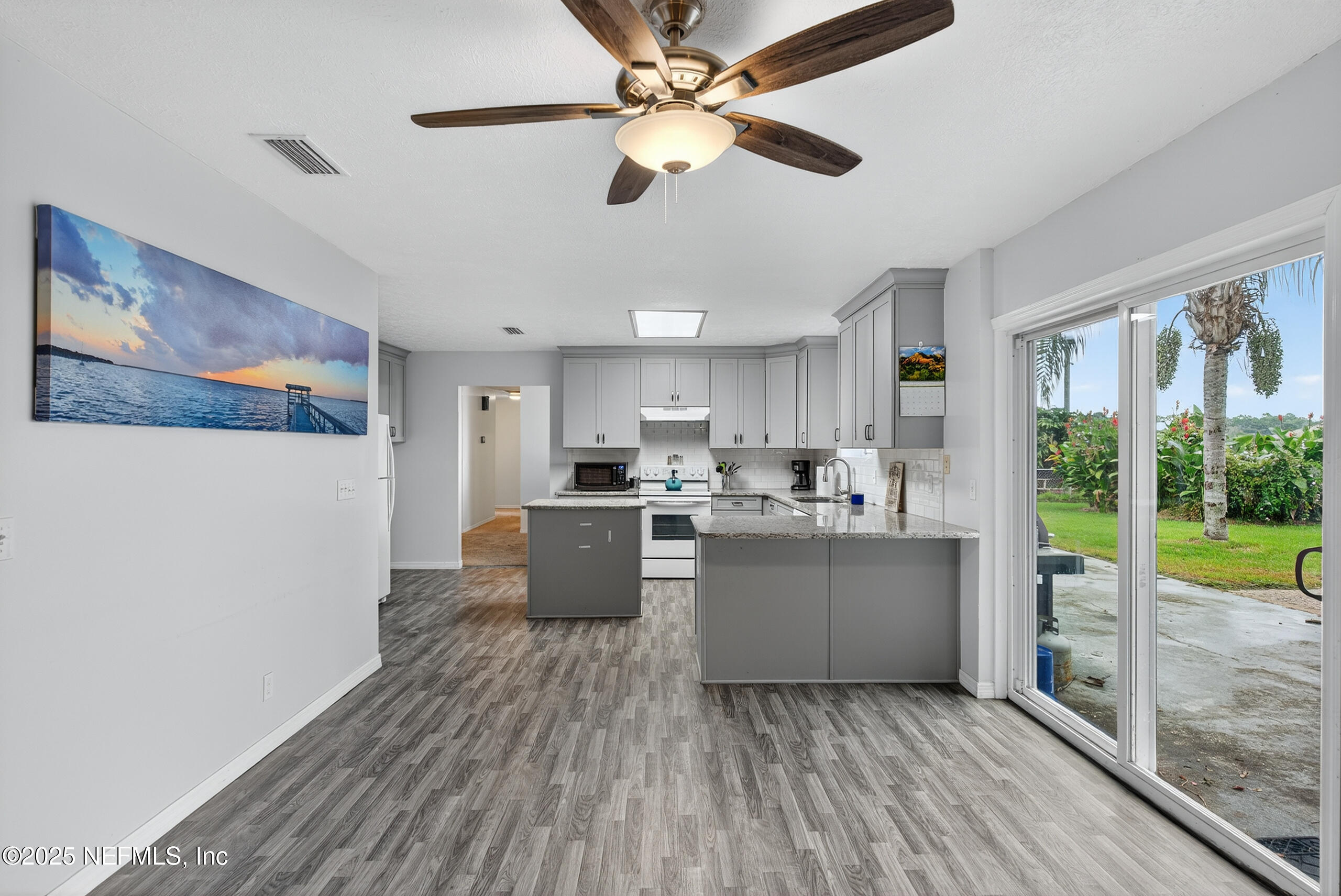 4429 Cedar Road Orange Park, FL 32065 - Photo 14 of 50 a kitchen with stainless steel appliances granite countertop a stove top oven a sink with wooden cabinets and wooden floor