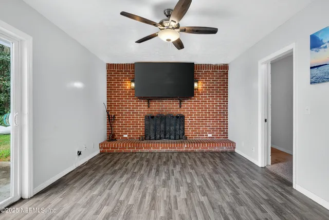 a view of an empty room with a fireplace and a window