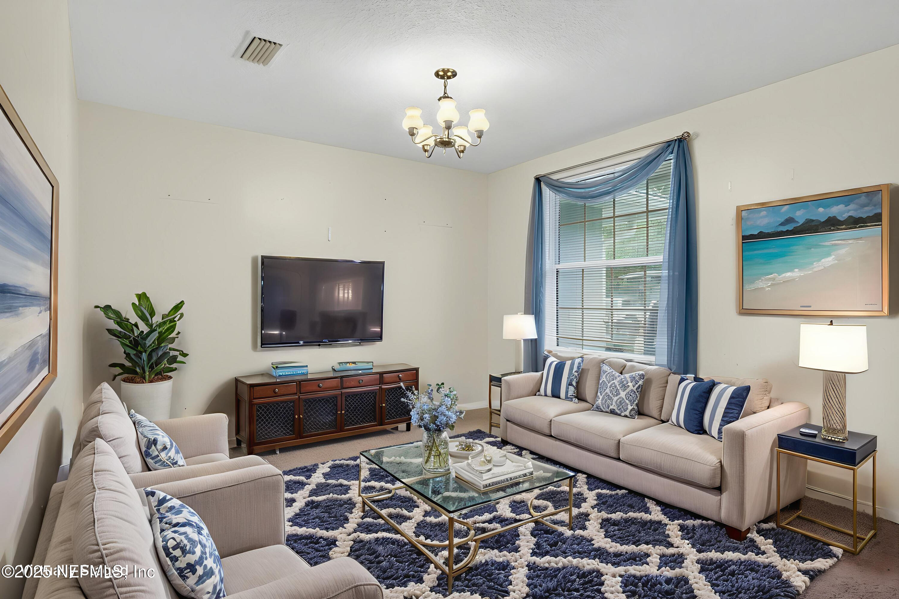 4429 Cedar Road Orange Park, FL 32065 - Photo 18 of 50 a living room with furniture a chandelier and a flat screen tv