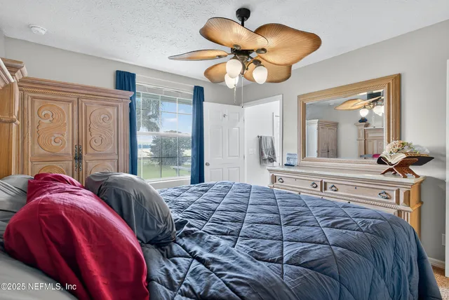 a bedroom with a large bed and a chandelier