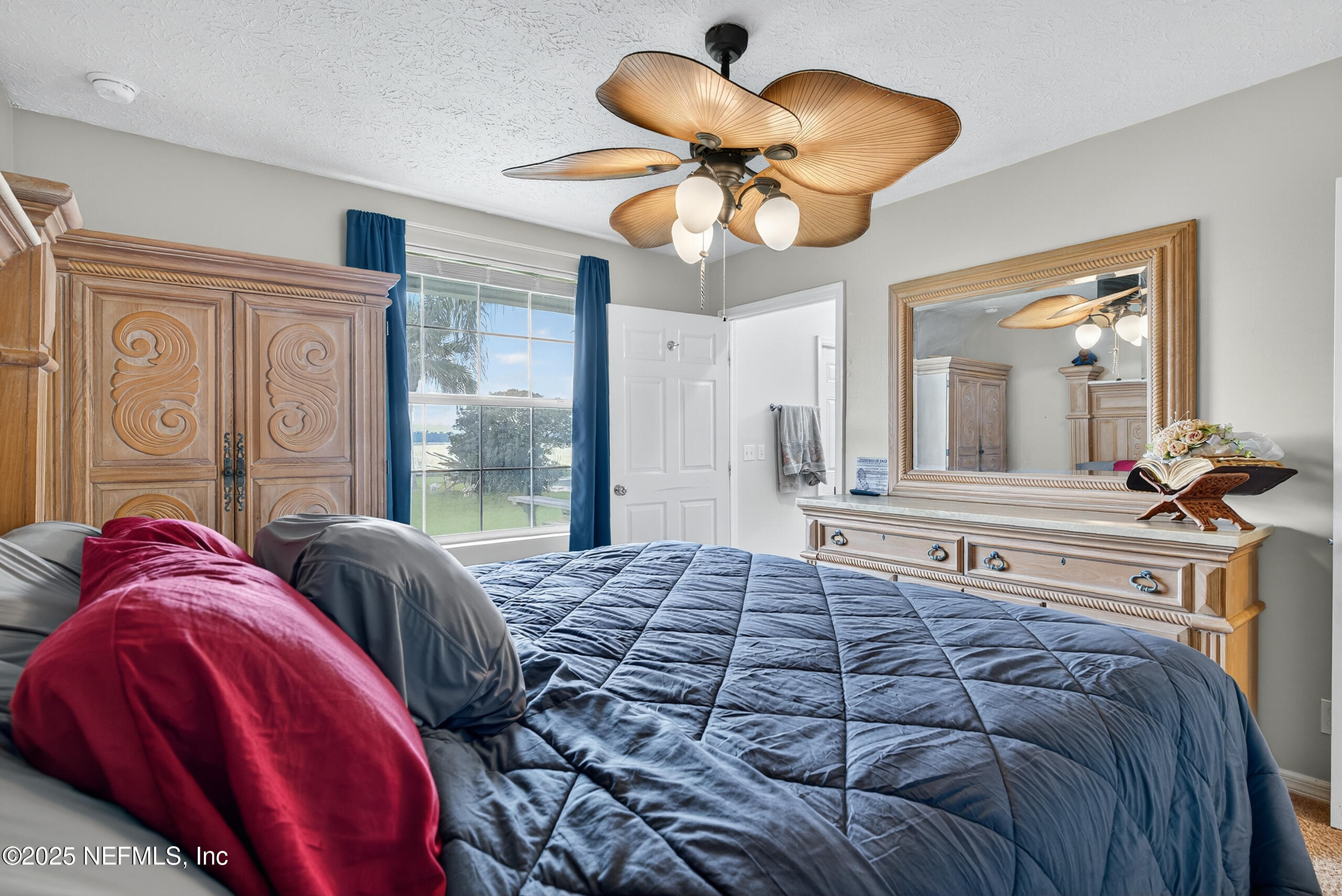 4429 Cedar Road Orange Park, FL 32065 - Photo 24 of 50 a bedroom with a large bed and a chandelier