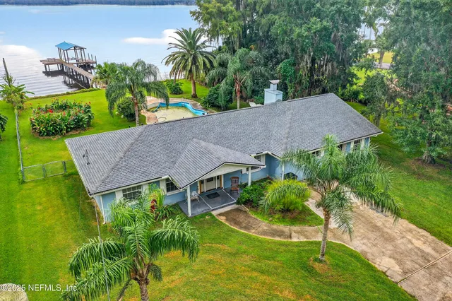 an aerial view of a house with swimming pool and garden
