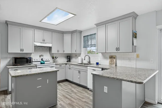 a kitchen with stainless steel appliances granite countertop a sink stove cabinets and refrigerator