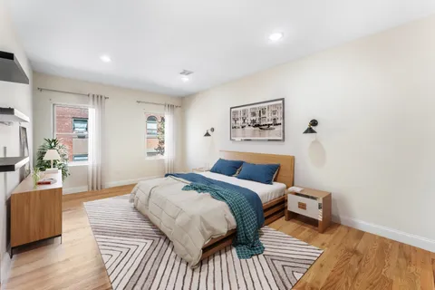 a bedroom with a bed and wooden floor