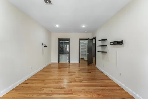 a view of empty room with wooden floor