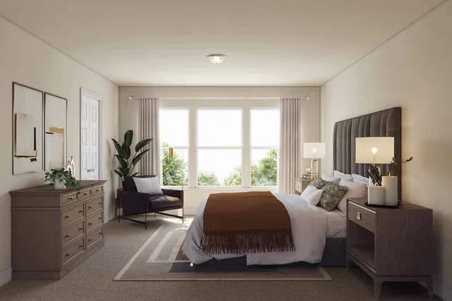 a bedroom with a bed and large windows