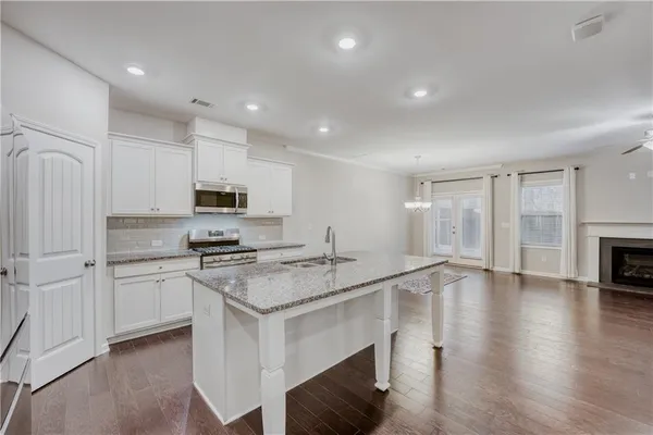 a kitchen with stainless steel appliances granite countertop a stove a sink and a refrigerator