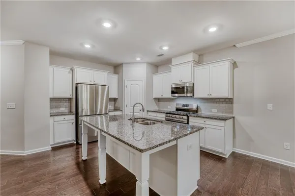 a kitchen with stainless steel appliances granite countertop a sink stove and refrigerator