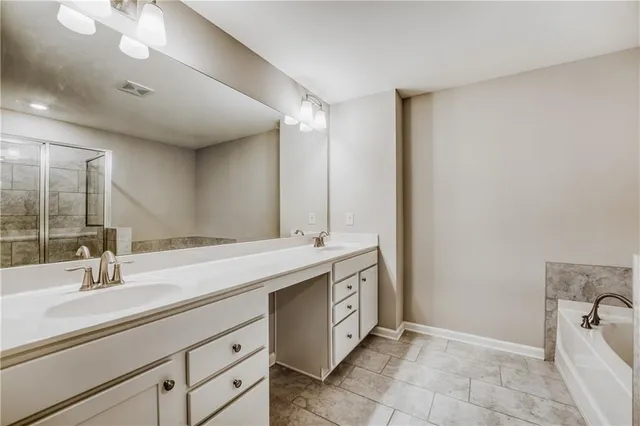 a spacious bathroom with a double vanity sink a mirror and a bathtub