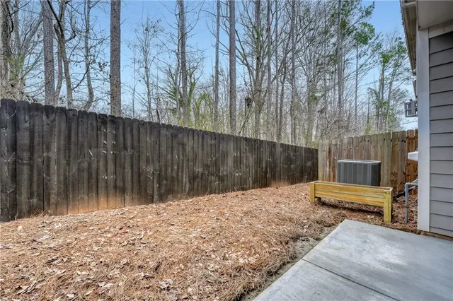 a backyard of a house with chairs and wooden fence