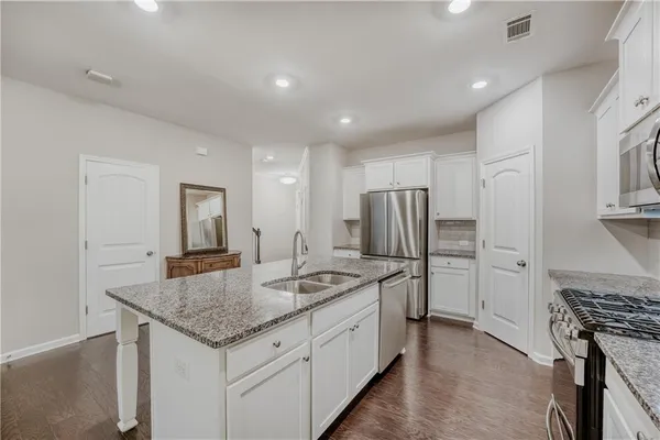 a kitchen with stainless steel appliances granite countertop a sink stove and refrigerator