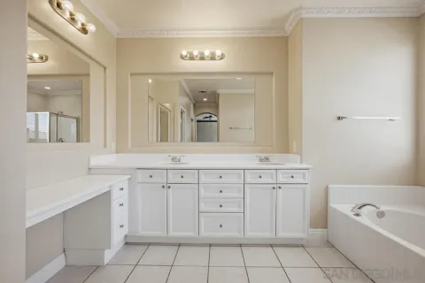 a spacious bathroom with a granite countertop sink a mirror a vanity and bathtub