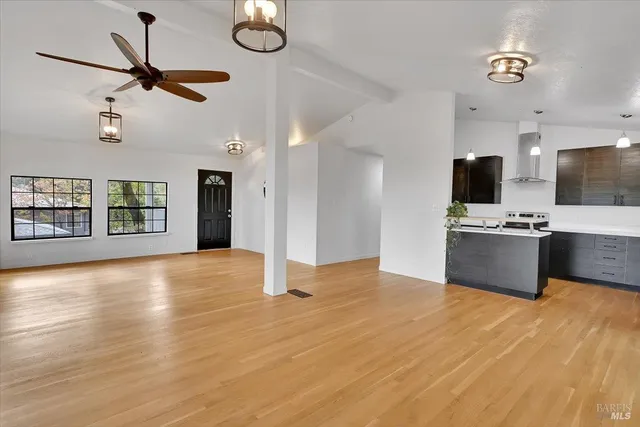a view of n empty room with window and wooden floor