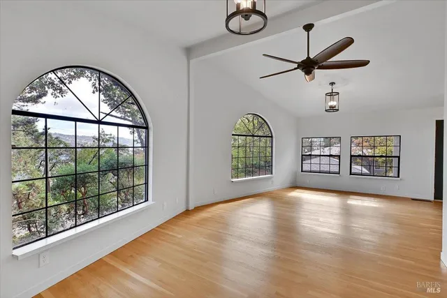 a large kitchen with a wooden floor and stainless steel appliances