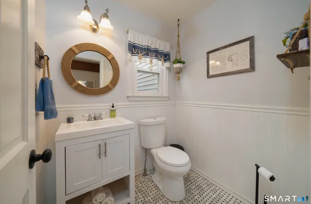 a bathroom with a toilet a sink and mirror