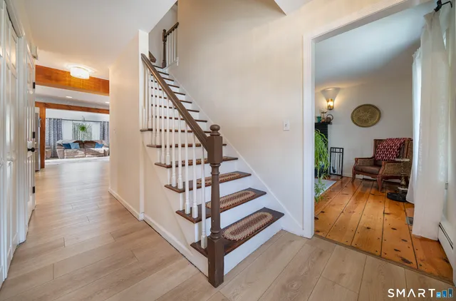 a view of a livingroom with wooden floor and furniture