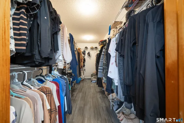 a view of walk in closet with clothes and shoes