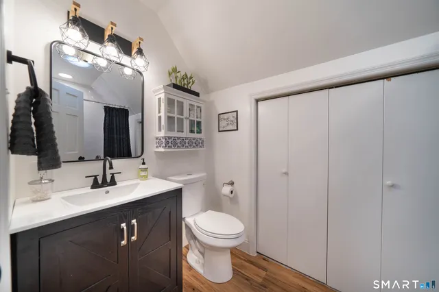 a bathroom with a toilet a sink a mirror and a shower