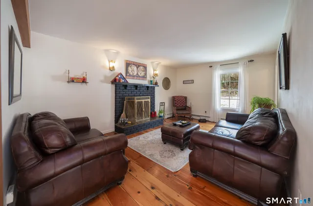 a living room with furniture fireplace and a window