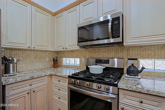 a bathroom with a granite countertop toilet a sink and a mirror
