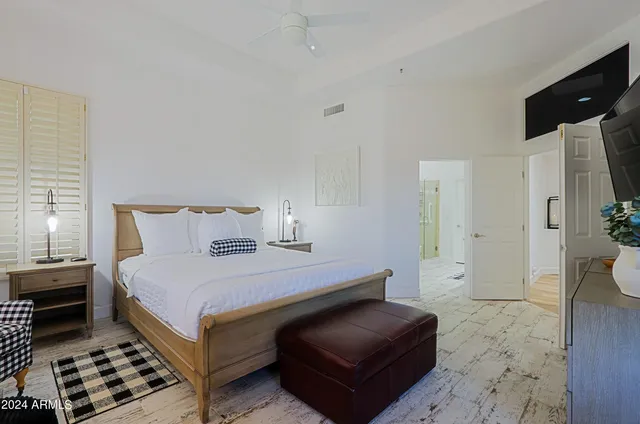 a bedroom with a bed and wooden floor