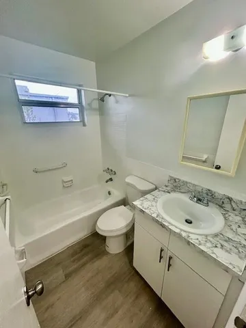 a bathroom with a granite countertop toilet sink and mirror