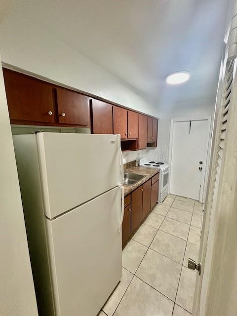 7511 Venetian Street, Unit 8 Miramar, FL 33023 - Photo 4 of 15 a kitchen with a refrigerator a stove top oven and cabinets