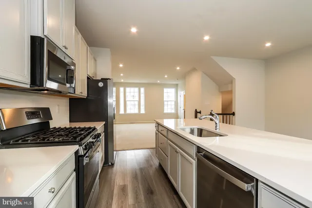 a kitchen that has a sink and a stove top oven