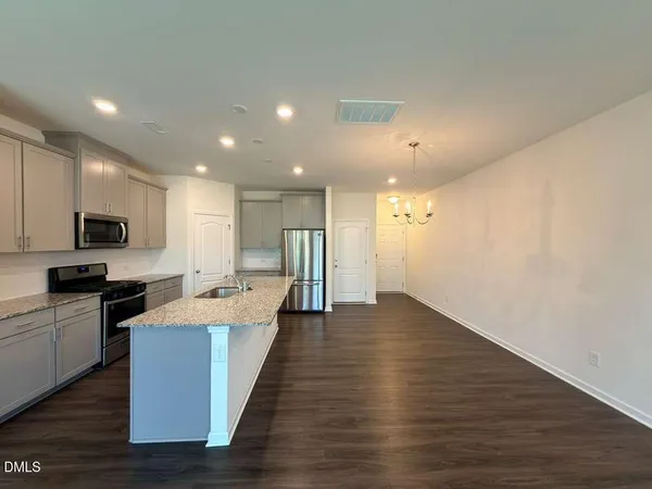 a large kitchen with a large counter top space stainless steel appliances and cabinets