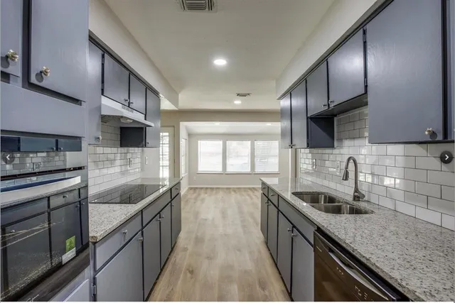 a kitchen with stainless steel appliances granite countertop a sink stove and cabinets