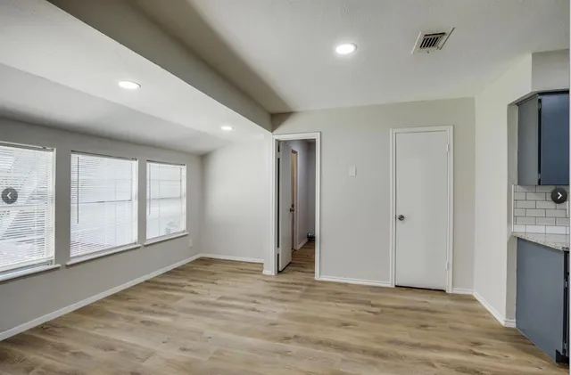 an empty room with windows and closet