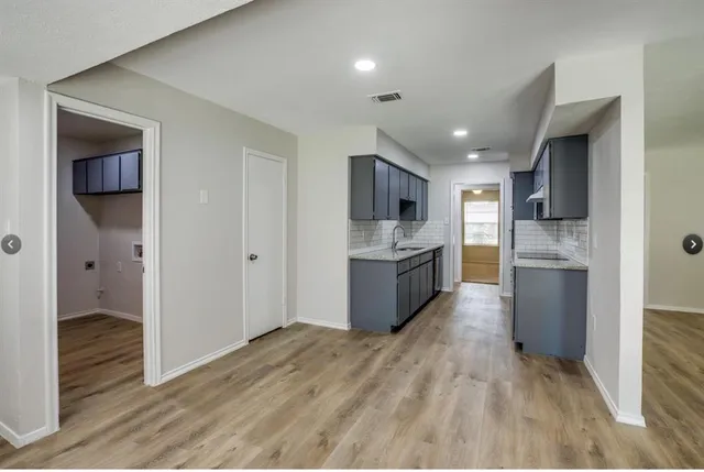 a large kitchen with a refrigerator and a stove top oven