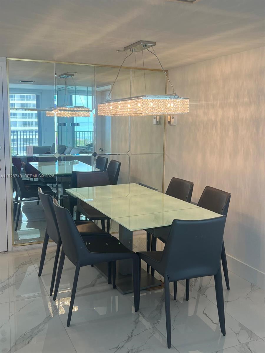 9273 Collins Avenue, Unit 606 Surfside, FL 33154 - Photo 12 of 18 a view of a dining table and chairs in a room