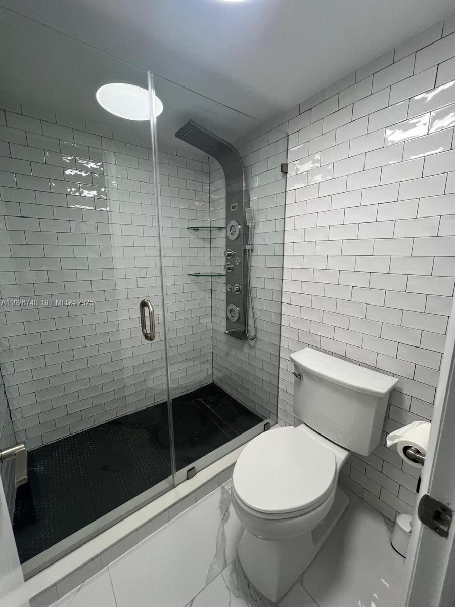 9273 Collins Avenue, Unit 606 Surfside, FL 33154 - Photo 15 of 18 a bathroom with a toilet and a shower