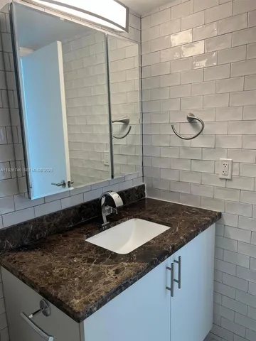 a bathroom with a granite countertop bathtub toilet and sink
