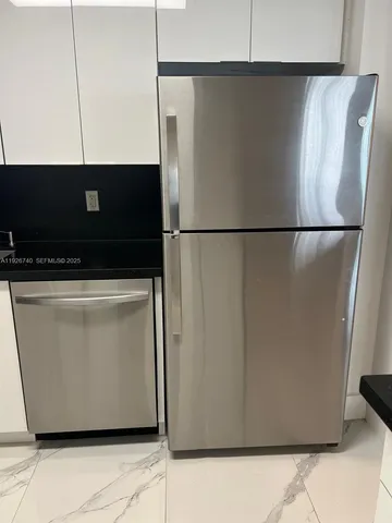 a view of a refrigerator in an empty room