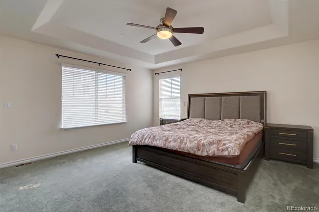a spacious bedroom with a bed and a ceiling fan