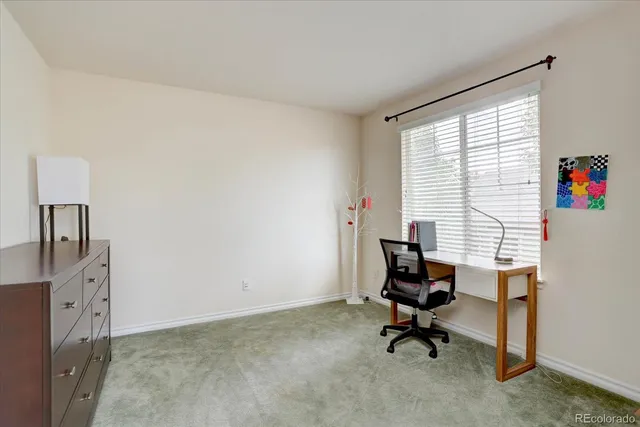 a view of a workspace with furniture and a window