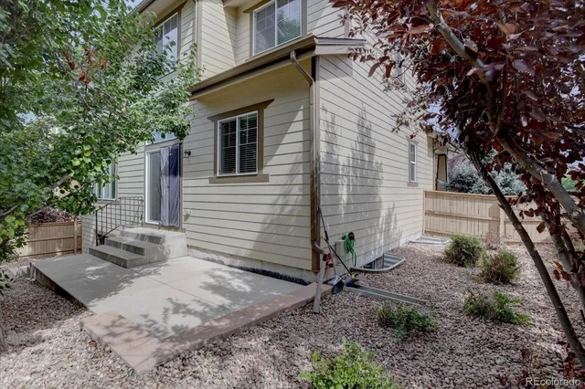 a view of a house with backyard and trees