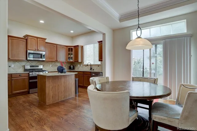 a kitchen with kitchen island a dining table and chairs
