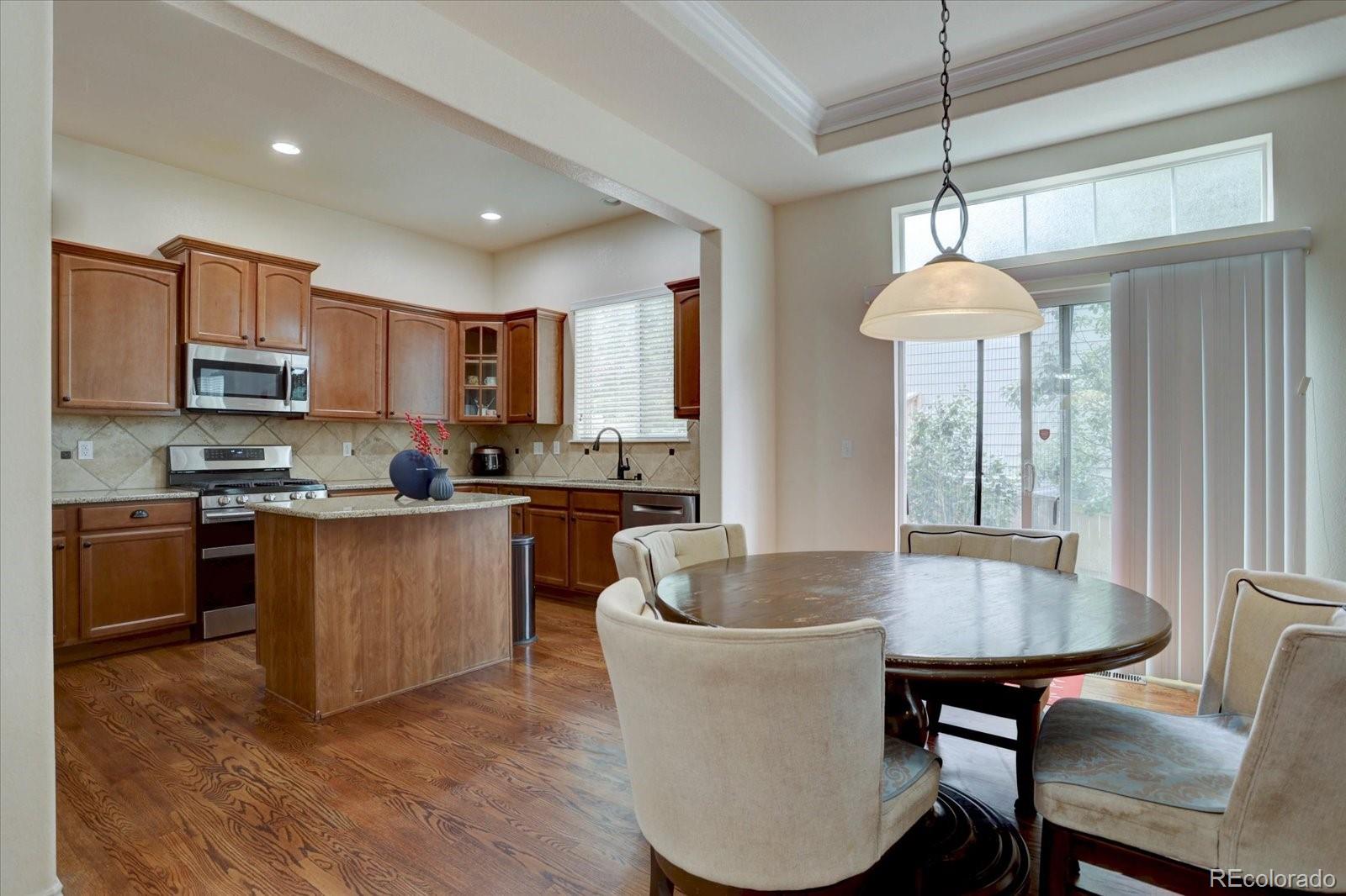5300 Fullerton Lane Highlands Ranch, CO 80130 - Photo 5 of 31 a kitchen with kitchen island a dining table and chairs