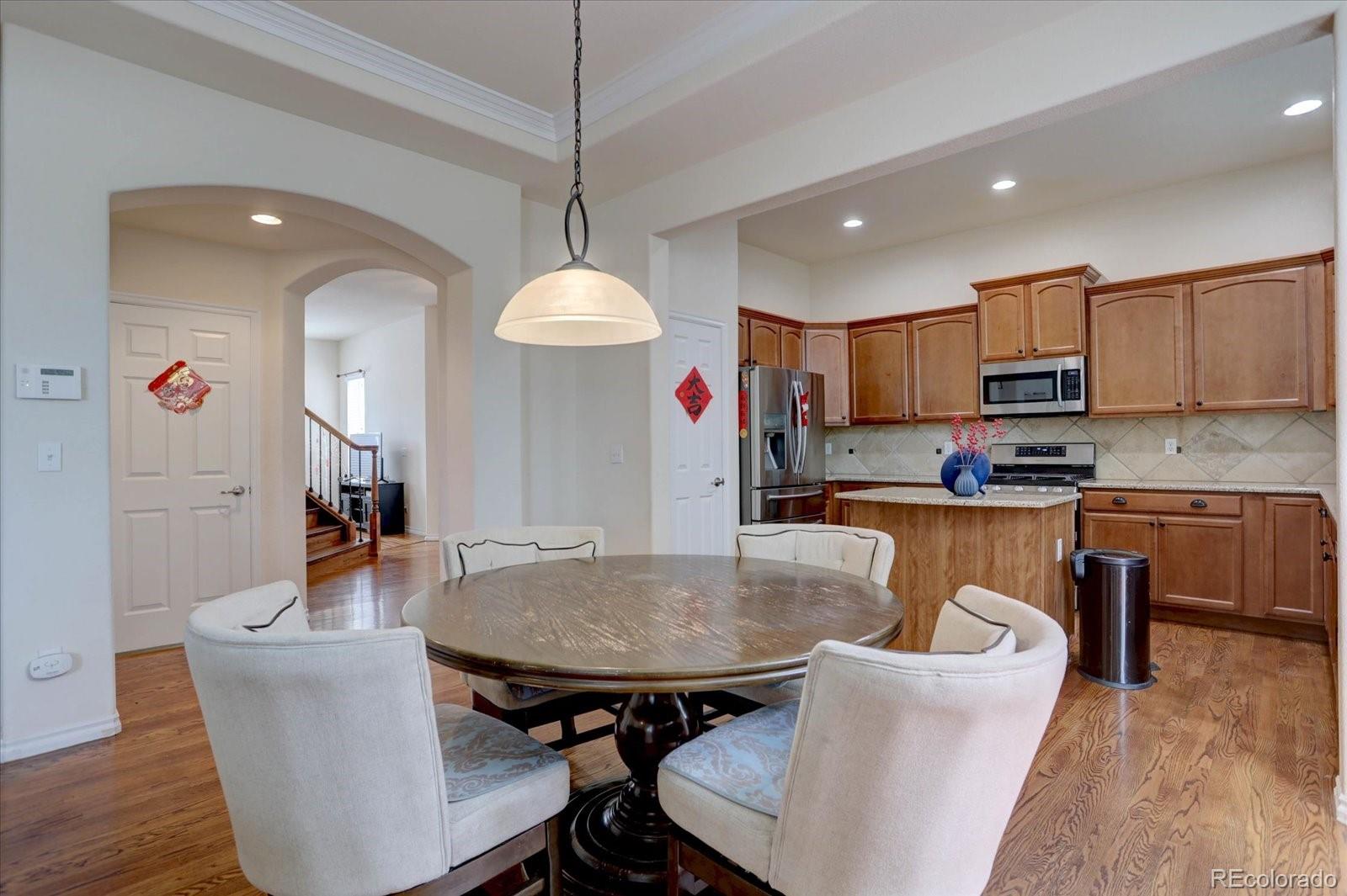 5300 Fullerton Lane Highlands Ranch, CO 80130 - Photo 6 of 31 a living room with stainless steel appliances kitchen island granite countertop a dining table chairs and a kitchen view