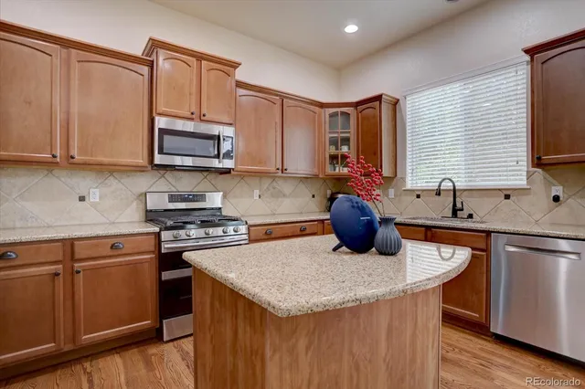 a kitchen with stainless steel appliances granite countertop a sink stove and microwave
