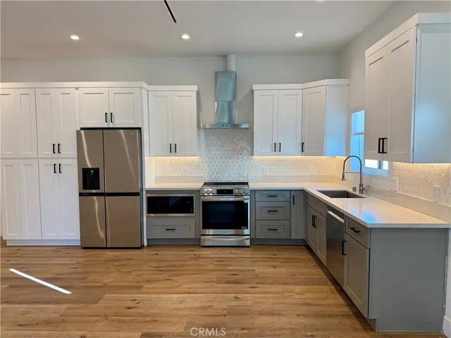 a kitchen with stainless steel appliances granite countertop a refrigerator and a stove