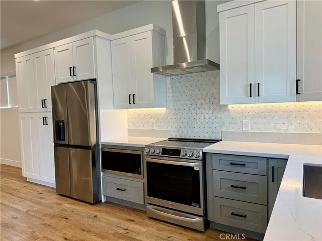 a kitchen with granite countertop white cabinets and stainless steel appliances