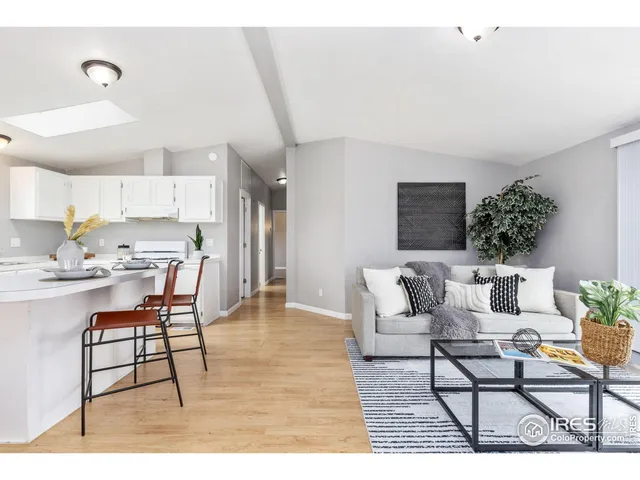 a living room with furniture and a dining table with kitchen view